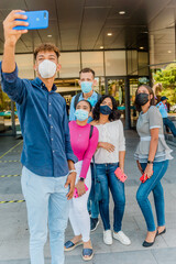 Obraz premium Grupo de jóvenes tomándose un selfie con cubre bocas