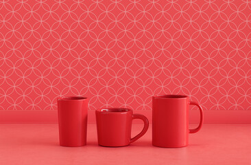 Two single red color water glasses and a coffee mug side by side on monochrome red color kitchen counter top with wall, close up front view, 3d rendering, no people