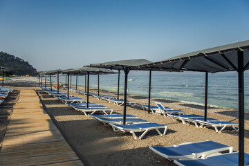 Fototapeta premium Row of empty sun loungers on the beach in Kemer Antalya
