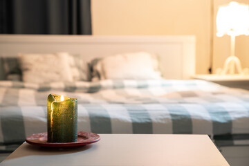 cozy bedroom detail focus on burning candle