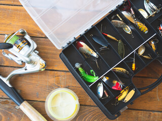 background fishing gear and fishing rods. fishing rod, spinning rod and various baits on a wooden table with a place for text