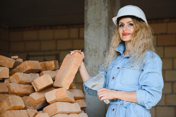 Woman with brick in construction concept