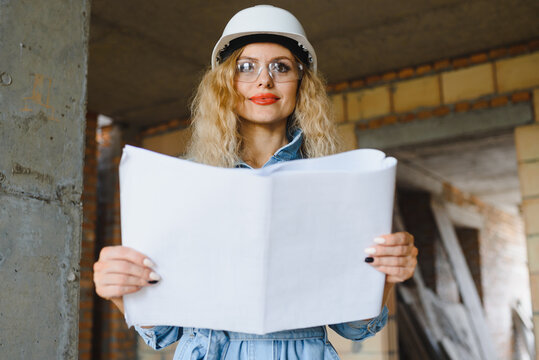 Warehouse woman worker. Woman builder in hardhat. Girl engineer or architect. Home renovation. Quality inspector. Construction job occupation. Construction worker. Lady at construction site.
