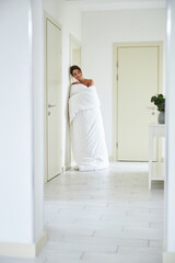 Laughing charming elegant woman posing at the camera in white corridor in the home apartment