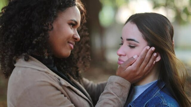 Two young women hugging in support and empathy together, two diverse people