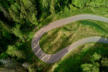 Fototapeta premium Sharp turn on forest track, roller ski track in wilderness, aerial view