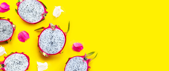 Dragon fruit or pitaya with bougainvillea flowers on yellow background.