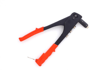 A riveter for crimping aluminum rivets. Tools for assembly in a machine shop. Light background.