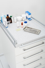 high angle view of dental tools in metal tray and medicines on table in clinic.