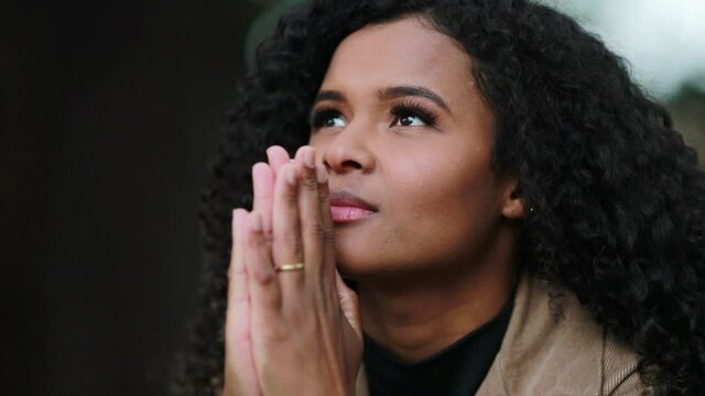 Black woman face praying to God. Hopeful Brazilian girl