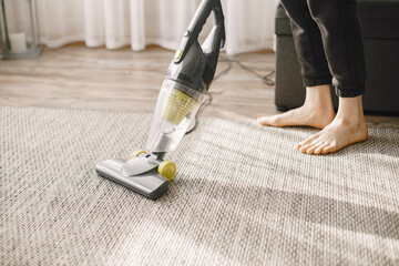 Woman vacuuming mat at home in a good mood