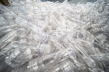 The various type of plastic bottle product and preform material with injection mold background. Drinking container manufacturing processing.