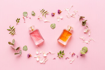 Perfume bottles flat lay with flowers and leaves, top view