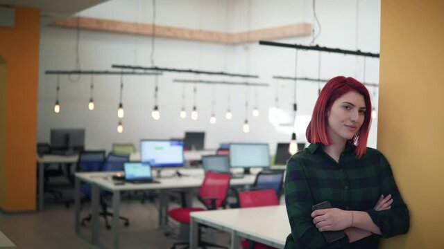 Portrait of smiling young female developer as a successful independent business lady posing in a modern office. Business, start up, development and feminism concept