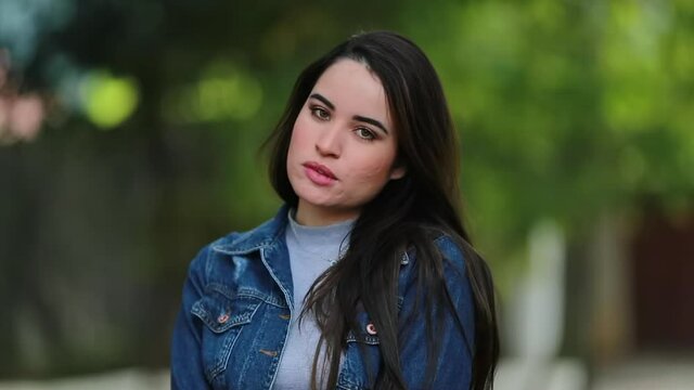 Pretty girl seducing camera. Young woman pressing lips standing outside portrait