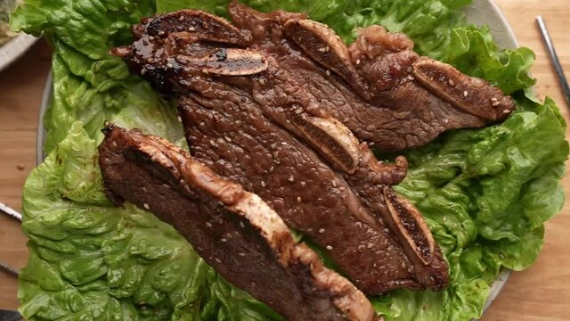 dropping korean style bbq short rib on lettuce slow motion 240p