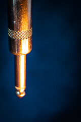 Closeup of Worn Out Quarter Inch Jack Hanging Downwards Against Teal Backdrop