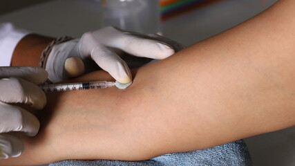 A doctor injected into a vein on a close arm.