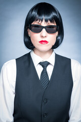 Cheeky Young Citizen with Black Hair, Dark Suit, Red Lips and Mysterious Shades.