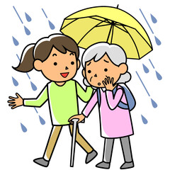 雨の中避難する高齢者を支援する女性