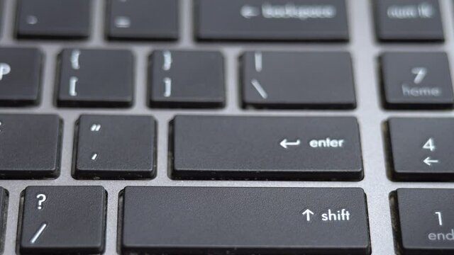 Enter button pressing a lot of times on keyboard, laptop keyboard close up