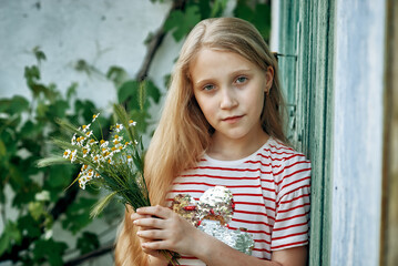 Portrait of a beautiful little girl with a bouquet of daisies