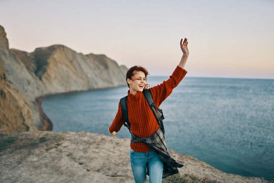 woman tourist gesturing with her hands in the mountains near the sea in nature top view
