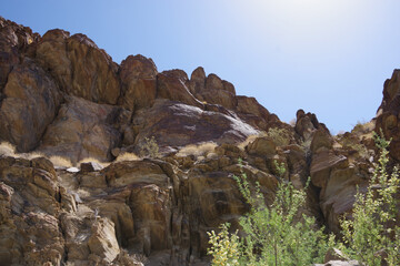 Fototapeta na wymiar Scenic view of rock formations and tree tips in the sunlight in a California desert mountain range