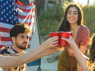 Group of young people clinking plastic red cups at a party