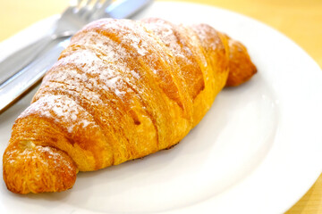 Bread croissants in a white plate on the table