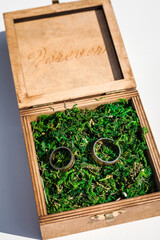 Wedding rings in a wooden box filled with moss