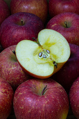 たくさんのりんごの上に乗った半分に切ったみずみずしい蜜の入ったりんご