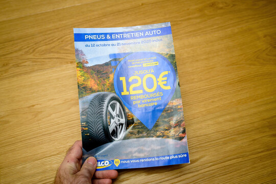 Paris, France - Dec 14, 2020: Overhead Shoot Pov Of Male Hand Reading Flyer Catalogue With Diverse Accesories For Car Such As Tires And Accesories Fomthe Vulco Brand