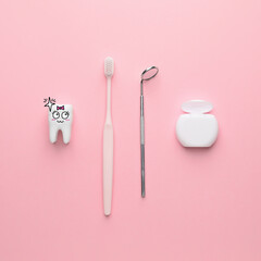 Dental mirror with toothbrush, floss and funny tooth on color background