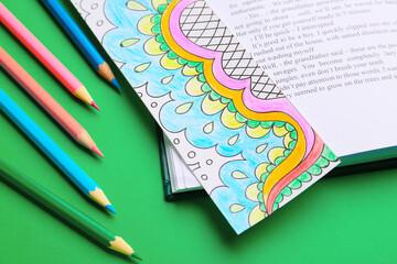Cute bookmark with book and pencils on color background