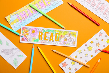 Cute bookmarks with pencils on color background