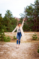 Obraz premium Young beautiful blonde long haired woman with raised hands over green natural forest background outdoor.
