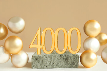 Number 4000 on a concrete podium and volumetric golden balls on a beige background. Copy space.. - obrazy, fototapety, plakaty