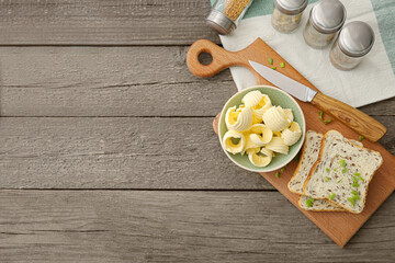 Bowl with fresh butter on wooden background