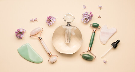 Beauty gadgets. Facial Rollers and guasha scrapers for facial massage on a light beige background. Flat lay, top view. Massage tools for face care