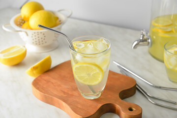 Glass of tasty cold lemonade on table