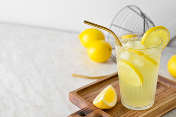 Composition with glass of tasty cold lemonade and fruits on table