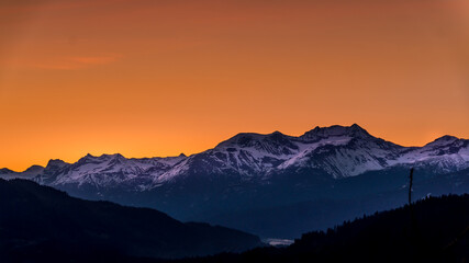 Fototapeta na wymiar Sunrise over the Garibaldi Mountain Range with the northern most peak of Mt. Currie in the range in the distant. Viewed from Whistler RV Park plateau, British Columbia, Canada