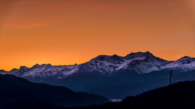 Sunrise over the Garibaldi Mountain Range with the northern most peak of Mt. Currie in the range in the distant. Viewed from Whistler RV Park plateau, British Columbia, Canada