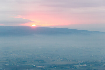Sunset over mountains and misty valley