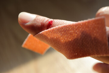 sticky plaster on the fingers, Applying adhesive bandage on bleeding finger.