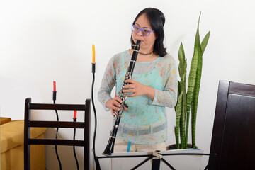 Girl with down syndrome, receiving virtual clarinet classes. Virtual classes concept.