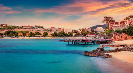 Colorful spring sunset in Ksamil town. Amazing evening seascape if Ionian sea. Exciting outdoor scene of Butrint National Park, Albania, Europe. Traveling concept background..