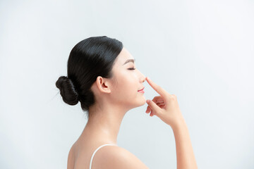 Side profile of asian lady pointing her nose - obrazy, fototapety, plakaty