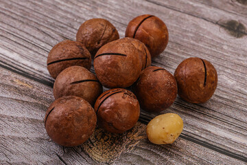 Brown macadamia nut heap over background